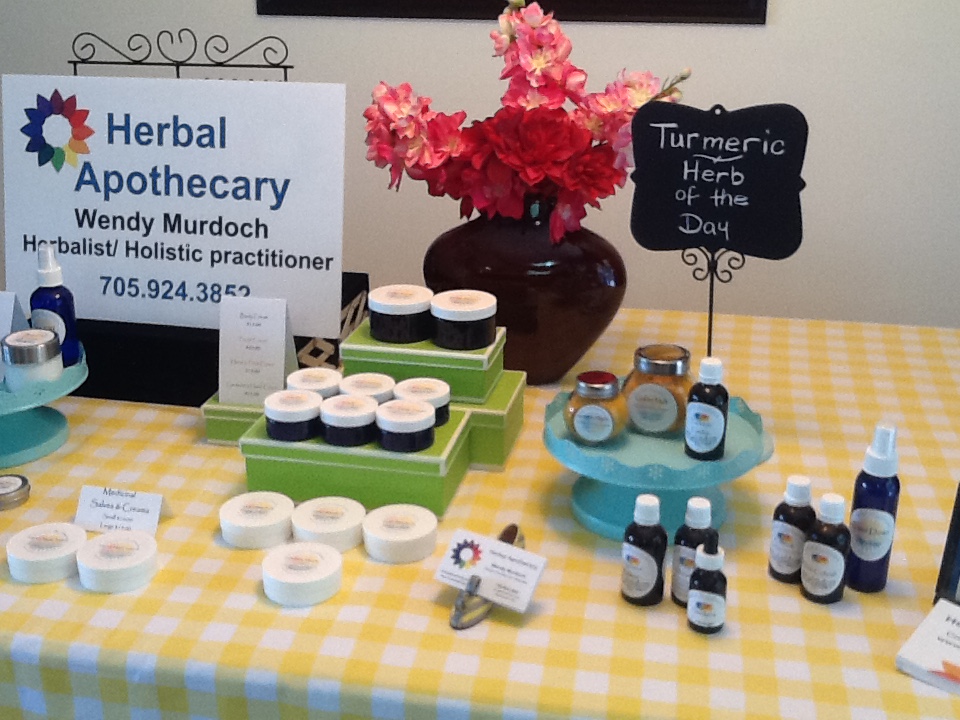  A picture of herbs, jars, creams on a table for an Herbal Apothecary show 