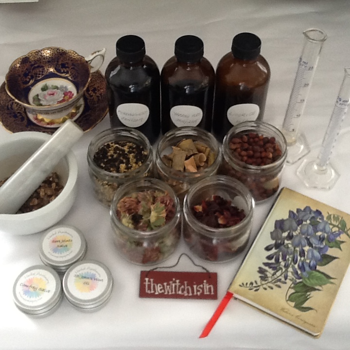 Tincture bottles, herbs, mortar & pestle, beakers all on a table 